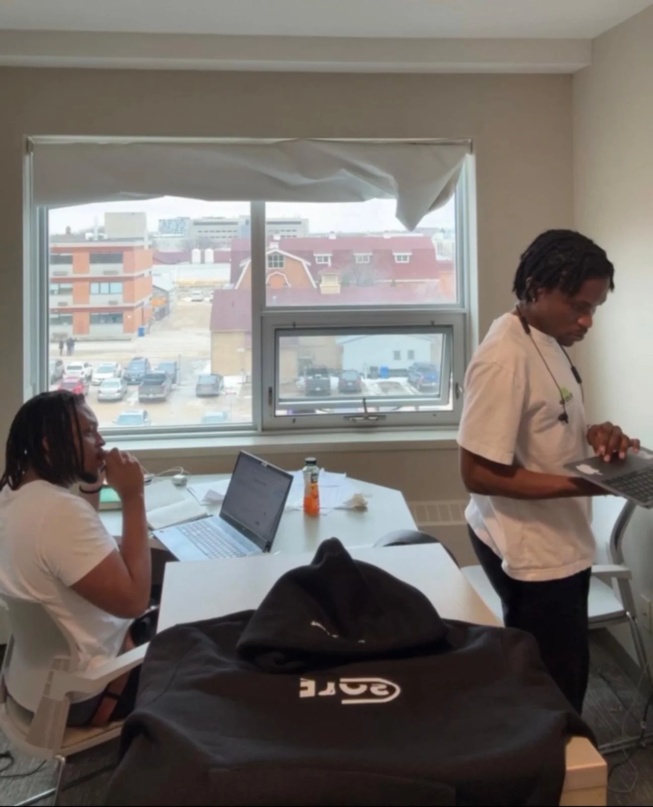 Two of the founders working on laptops in a campus study room